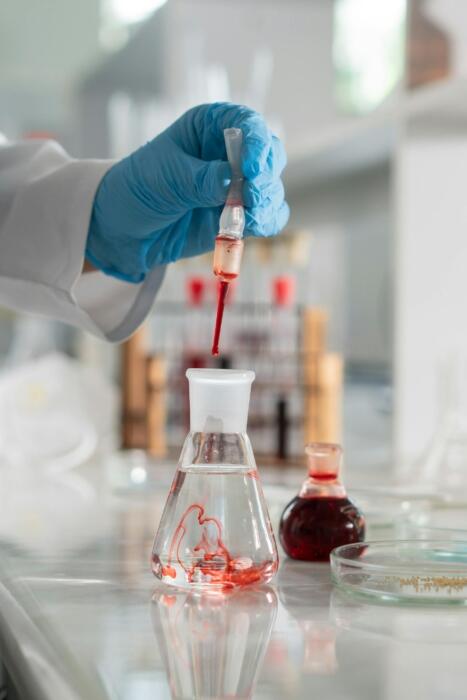 pessoa a verter pipeta de sangue em laboratório